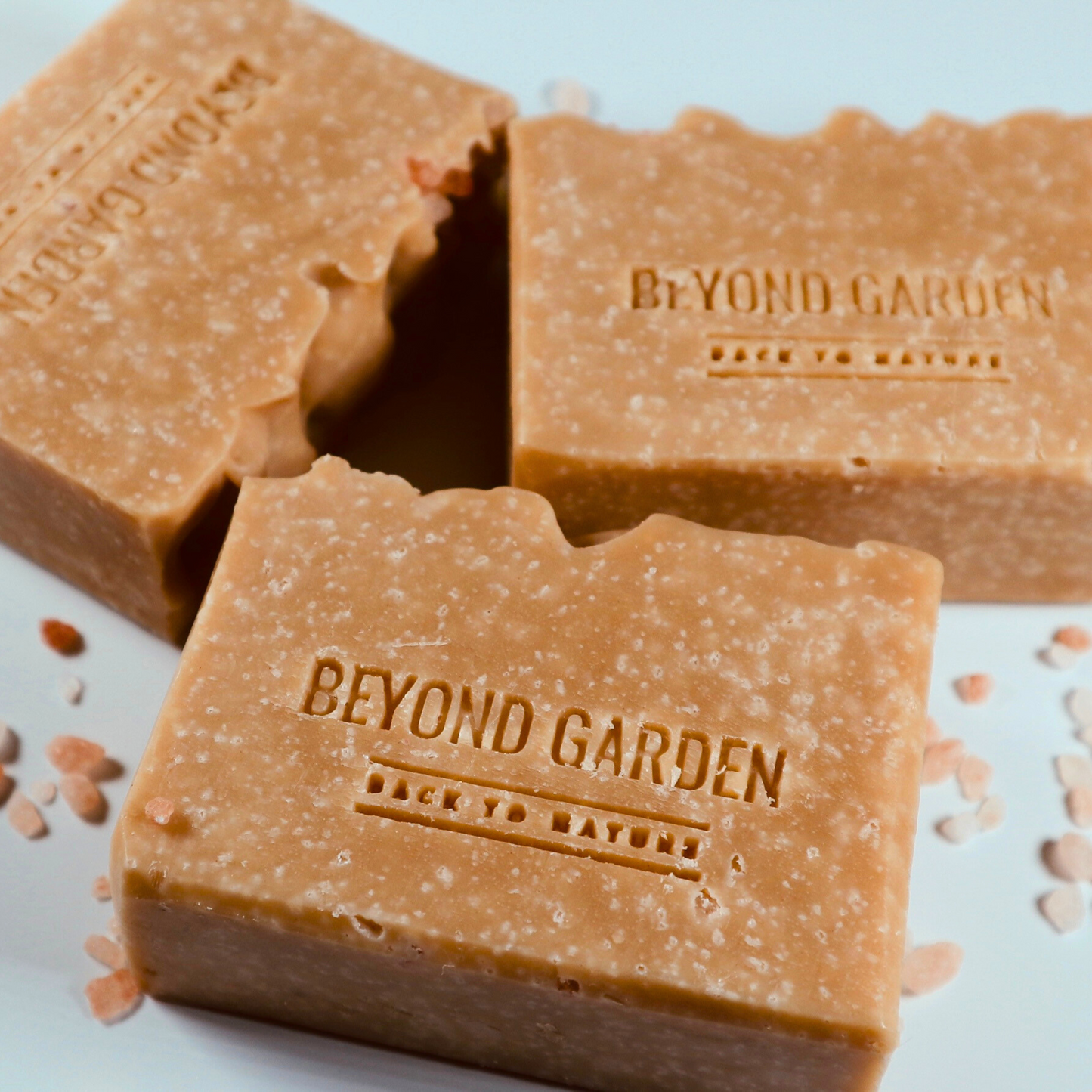 Three natural salt soap bars displayed on a table, with the front of each bar prominently visible, highlighting their texture and handmade details.