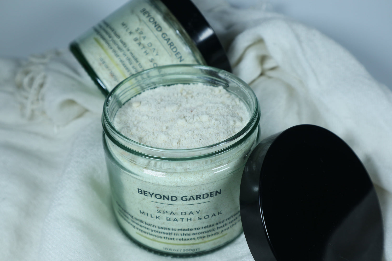 bath salt glsss jar open showing bath soak with black lid 