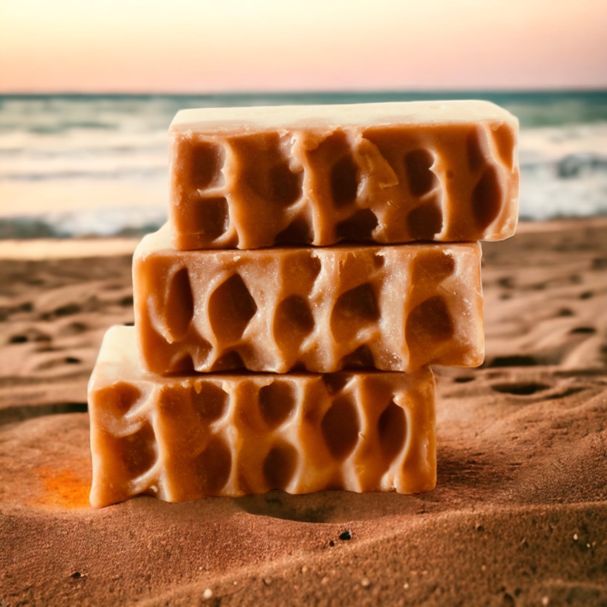 Three sea moss soap bars arranged on sand, emphasising their unique designs and natural design.